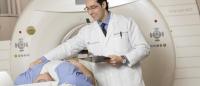 doctor standing next to patient in a CT scan